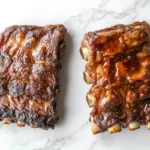 Raw country-style and short ribs displayed side-by-side on a white marble background.